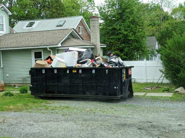 Rental dumpster from D. Barry Rubbish, overflowing with junk