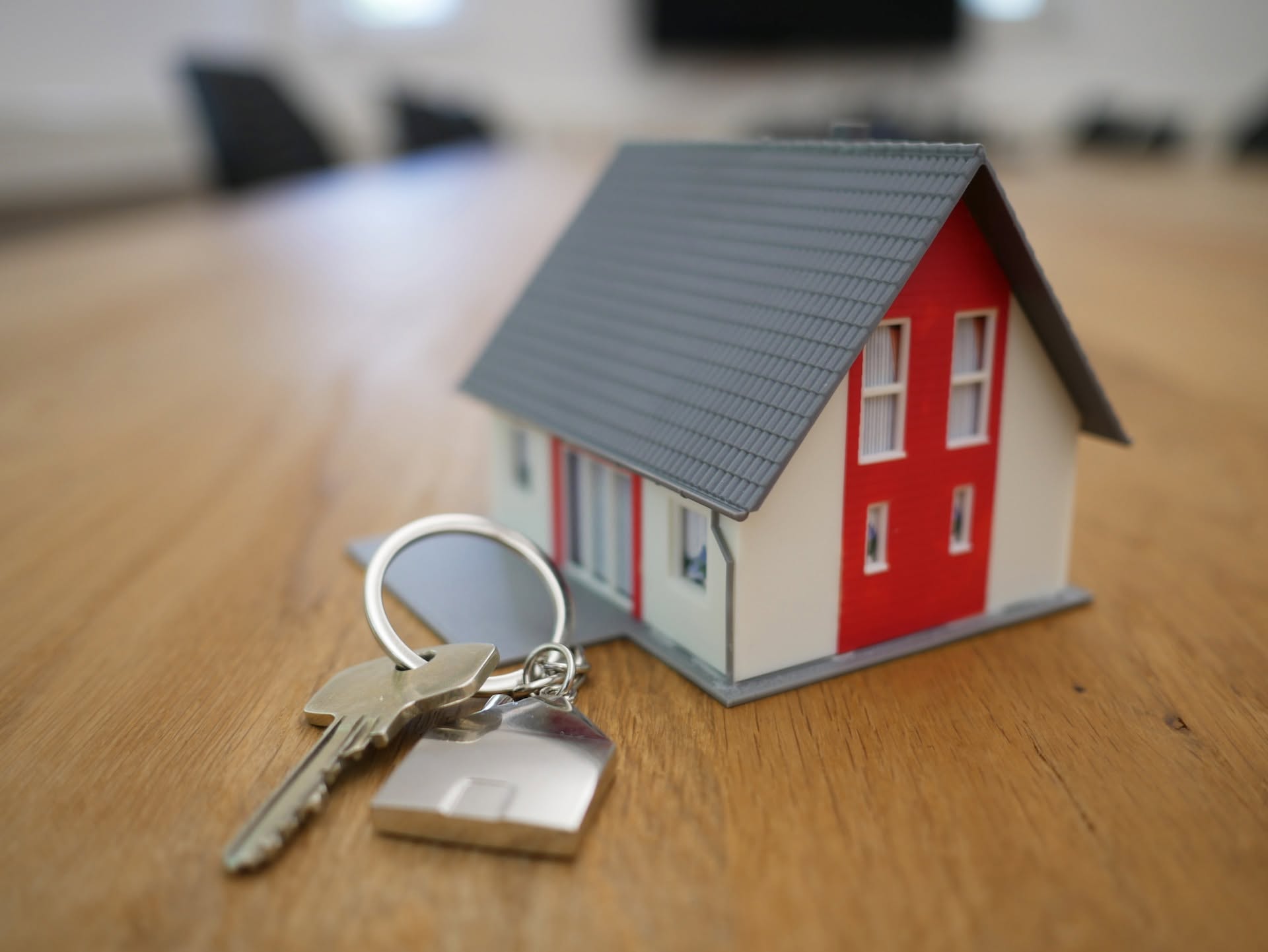 Small model of a house on a table with real house keys